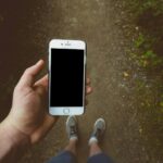 person holding silver iPhone 6 with black case