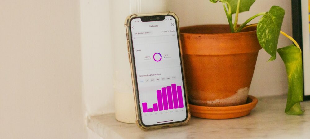 A cell phone sitting on top of a table next to a potted plant